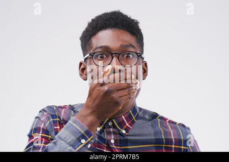 C'est la chose la plus choquante que j'ai entendue aujourd'hui. Photo studio d'un jeune homme qui a l'air choqué sur un fond gris Banque D'Images