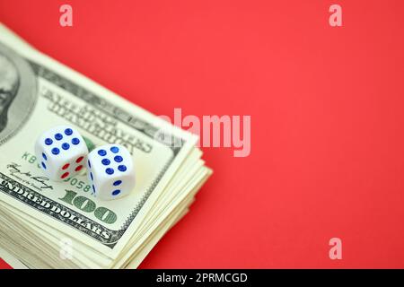 Concept d'argent, de finance et de jeu. Gros plan sur une centaine de billets américains et deux dés blancs en haut montrant les chiffres six et six Banque D'Images