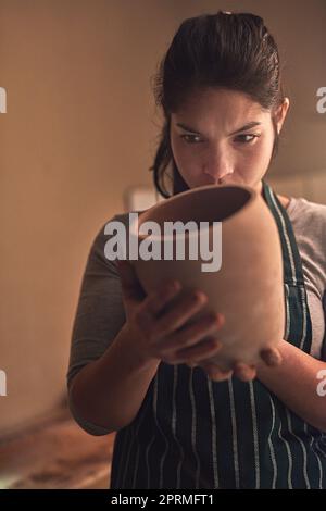 La réalisation de sa dernière conception. Une artiste en céramique travaillant sur sa poterie dans un atelier. Banque D'Images