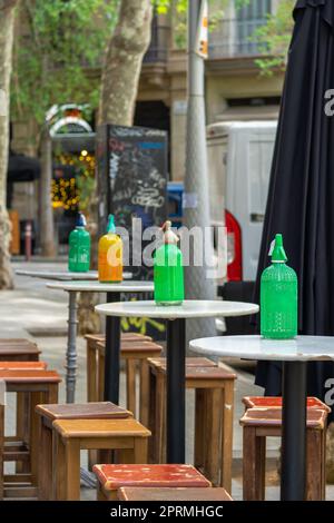 Siphons en maille de plastique jaune et vert orange antique et vintage pour soda sur les petites tables rondes en marbre sur la terrasse d'un vieux pittoresque Banque D'Images