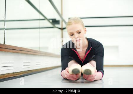 Préparer ses muscles à bouger. Une jeune femme pratiquant le ballet. Banque D'Images