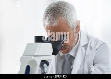 Axé sur la découverte scientifique. Chercheur au travail sur un microscope dans un laboratoire. Banque D'Images