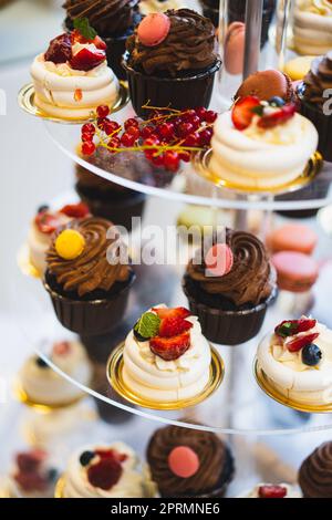 Délicieux réception de mariage bar de bonbons table de dessert avec divers bonbons, petits gâteaux, fruits et tartes. Banque D'Images