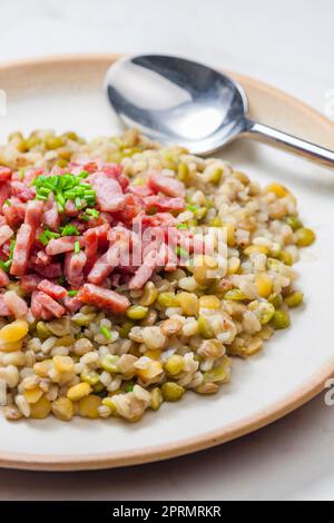 porridge de légumineuses avec bacon frit et ciboulette Banque D'Images