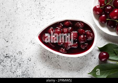 confiture de cerises et cerises fraîches dans un bol, conserves maison Banque D'Images