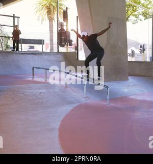 Le skateboard, son qui je suis. Un skateboarder effectuant un tour sur un rail. Banque D'Images