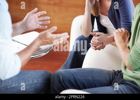 Obtenir des conseils solides d'une source expérimentée. Image rognée d'un jeune couple qui reçoit des conseils d'un homme mûr. Banque D'Images