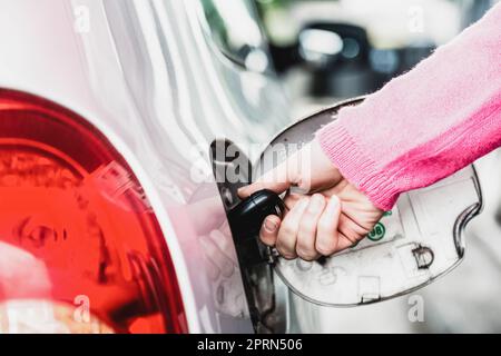 Gros plan du réservoir de carburant de voiture à ouverture manuelle femelle avec une clé. Banque D'Images