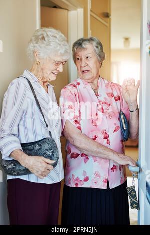 Si nous mettons un autre verrou de sécurité ici. deux femmes âgées ferment la porte avant de partir pour sortir Banque D'Images