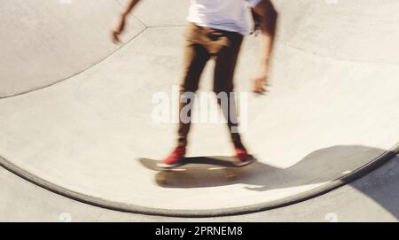 L'équilibre est essentiel dans tout ce qui se passe dans la vie. un homme méconnaissable qui fait des tours sur son skateboard dans un parc de skate. Banque D'Images