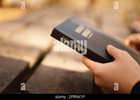 La jeune fille chrétienne tient la bible dans ses mains. Lecture de la Sainte Bible. Concept de foi Banque D'Images