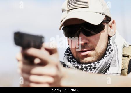 Il prend sa formation au sérieux. Coup de tête et d'épaule d'un soldat tenant un fusil et prêt à tirer pendant un entraînement Banque D'Images