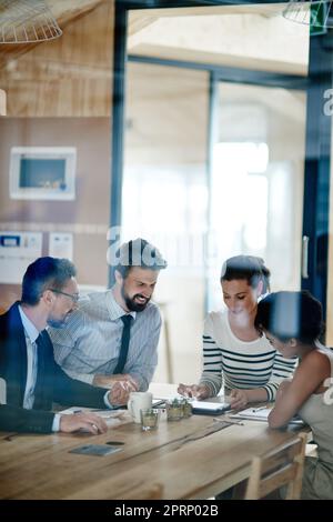 La réussite est à portée de main. Par la photo d'un groupe de collègues travaillant ensemble dans un bureau. Banque D'Images