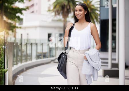 Un joyeux travailleur de la mode se déplace dans la ville ou dans la rue pour travailler, travailler ou travailler dans un immeuble de bureaux d'entreprise. Euro business girl ou woman souriez et détendez-vous tout en marchant en ville à la recherche de l'architecture et du design du bâtiment Banque D'Images