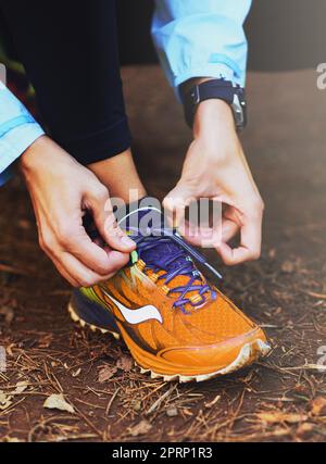 Laçage. Une femme a nouée ses chaussures de course avant une course sur piste. Banque D'Images