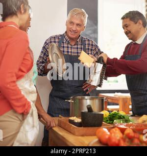 Les souvenirs sont faits maison. Un groupe de personnes âgées cuisant dans la cuisine. Banque D'Images