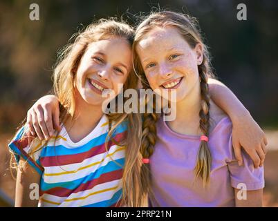 C'est le meilleur des amis. Portrait de deux jeunes filles debout ensemble à l'extérieur. Banque D'Images