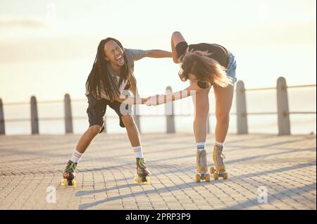 Liberté, plaisir et heureux couple riant et patinage à roulettes dehors ensemble, positif, ludique et gai. Copain et petite amie interracial excités, tout en appréciant la pratique du skate Banque D'Images