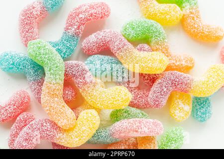 Bonbons en gelée colorés et savoureux sur fond blanc, vue de dessus. Banque D'Images