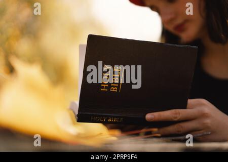 La jeune fille chrétienne tient la bible dans ses mains. Lecture de la Sainte Bible. Concept de foi Banque D'Images