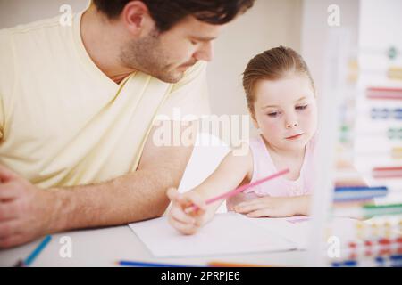 Elle fait toujours ses devoirs. Une petite fille fait ses devoirs. Banque D'Images