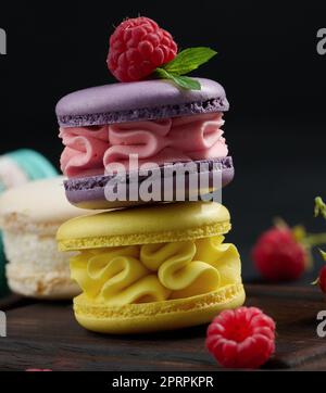 Une pile de macarons multicolores sur une planche de bois. Délicieux dessert Banque D'Images