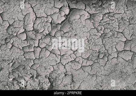 Contexte la terre ou la terre est fissurée et sèche pendant la sécheresse. Terre fissurée sèche représentant des conditions de sécheresse graves Banque D'Images