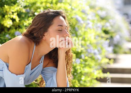 Une femme heureuse se détendant dans un jardin Banque D'Images