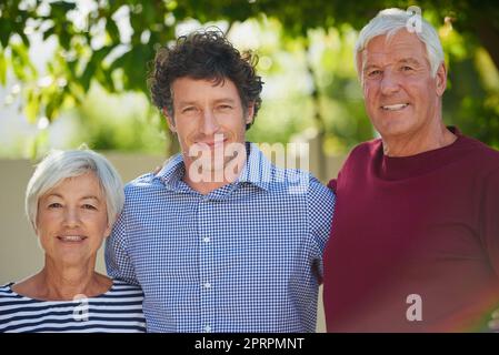 Nous ne pourrions pas être plus fiers. Portrait court d'un couple senior debout à l'extérieur avec son fils Banque D'Images