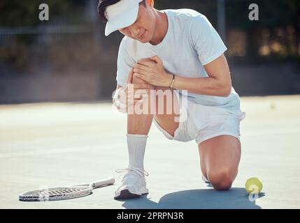 Sport, douleur et blessures de tennis par l'athlète homme tenant le genou pendant un match de compétition sur un court extérieur. Joueur de tennis asiatique professionnel souffrant de douleur musculaire, accident de forme physique pendant l'exercice Banque D'Images