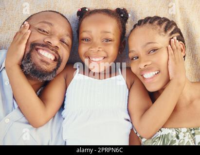 Amour, soin et bonne adhésion de famille noire, se détendre et se reposer ensemble à la maison d'en haut. Portrait des parents souriants appréciant le temps avec leur enfant, montrant l'affection et l'amour avec leur fille Banque D'Images