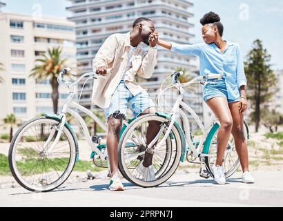 Black man, KISS Woman Hand et vacances dans un parc extérieur à miami. Couple sur la romantique date d'été, vélo dans la rue de ville et bonne amie. Petit ami amoureux, loisir en vélo et soleil Banque D'Images