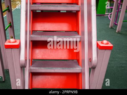 Gros plan de marches en bois sur un escalier rouge vide dans une aire de jeux extérieure, une aire de jeux pour les enfants Banque D'Images
