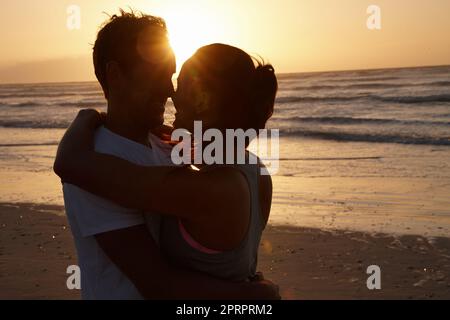 Savourez un moment romantique sur la plage. Silhouette de couple romantique à la plage au coucher du soleil. Banque D'Images