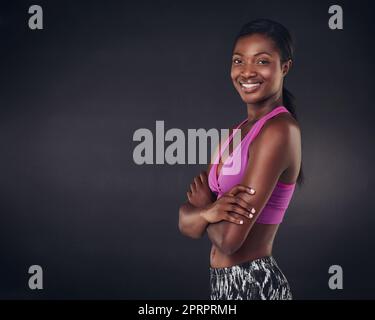 Belle apparence et sensation. Photo en studio d'une jeune femme magnifique prête pour un entraînement sur fond noir Banque D'Images