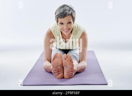 Je fais du yoga. Portrait complet d'une femme attirante qui s'étire avant le yoga. Banque D'Images