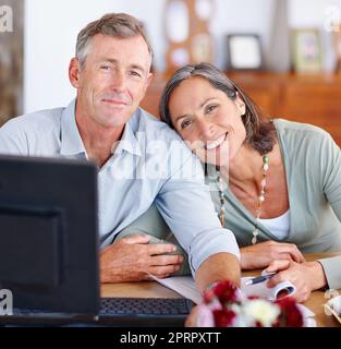 Rester à la tête de leurs revenus et dépenses. Portrait d'un couple marié mature passant par leurs finances à la maison. Banque D'Images