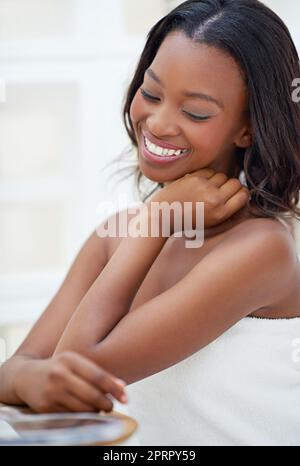 Elle n'utilise que le meilleur sur sa peau. Une jeune femme pendant son rituel de beauté quotidien. Banque D'Images