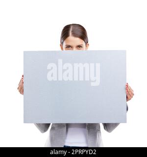 Nous allons vous faire remarquer. Photo studio d'une belle jeune femme tenant un écriteau vierge sur un fond blanc. Banque D'Images