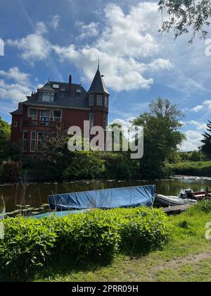 Belle vue de la maison près de la rivière avec bateau amarré le jour ensoleillé Banque D'Images