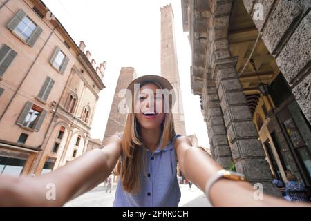 Une jeune fille touristique attirante prend son propre portrait avec Bologna Two Towers Landmark, Italie Banque D'Images