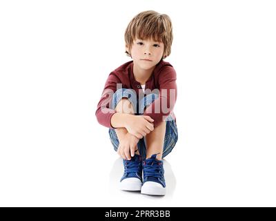 Où est tout le monde. Photo studio d'un petit garçon mignon qui embrasse ses genoux sur un fond blanc. Banque D'Images