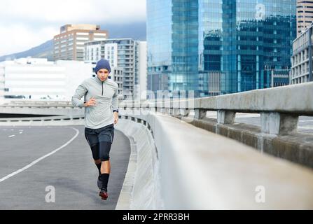 Course dans la ville. Un jeune homme qui fait du jogging dans les rues vides de la ville Banque D'Images