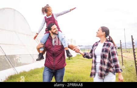 La famille, la ferme et les parents qui transportent des enfants marchent, se rassemblent et explorent la campagne ensemble. Agriculture, agriculture et fille sur l'épaule de papa va à c Banque D'Images