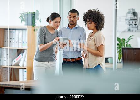 Mettre leurs idées en action. collègues de bureau ayant une discussion sur une tablette numérique Banque D'Images