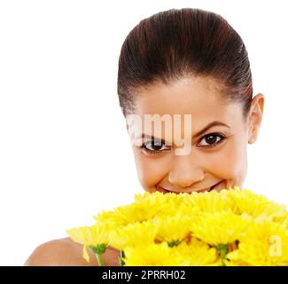 De magnifiques fleurs pour égayer votre journée. Portrait d'une femme heureuse tenant des fleurs jaunes sur un fond blanc. Banque D'Images