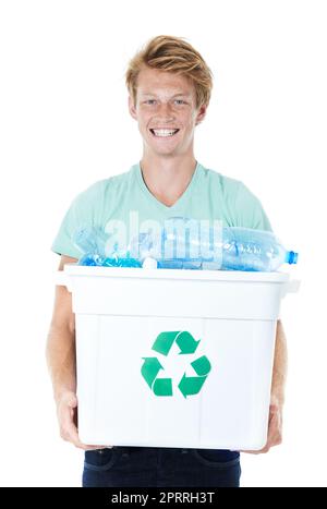 Réduisons nos déchets. Un jeune homme heureux à tête rouge tenant un bac de recyclage rempli de bouteilles en plastique vides. Banque D'Images