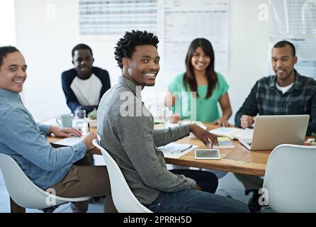 Tout cela sur la même page. Portrait de jeunes hommes d'affaires assis dans une salle de réunion. Banque D'Images
