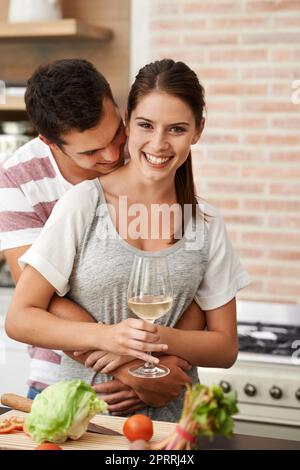 Combinant leur amour pour la nourriture et les uns les autres. Portrait d'un jeune couple attrayant liant dans la cuisine Banque D'Images