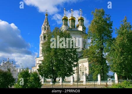 Une grande vieille église en pierre blanche sur fond de grands arbres et d'un ciel bleu Banque D'Images